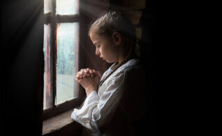 Girl praying at window